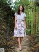 A woman walking down a path in a forest.