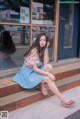 A woman sitting on the steps of a building.