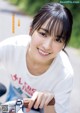 A young woman smiles while riding a bike. 