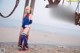 A woman in a blue and red outfit standing on a beach.