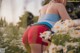 A woman in a field of daisies with her back to the camera.