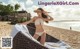 A woman in a bikini sitting on a beach chair.