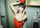A woman in a red bathing suit standing in a bathroom.