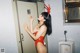 A woman in a red bathing suit standing in a bathroom.