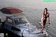 A naked woman standing on a boat in the water.